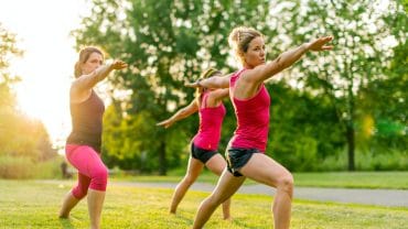 três mulheres alongam no parque, gastam energia e fazem alusão a energia das mitocôndrias