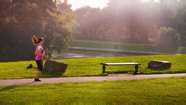 Mulher correndo em um parque.