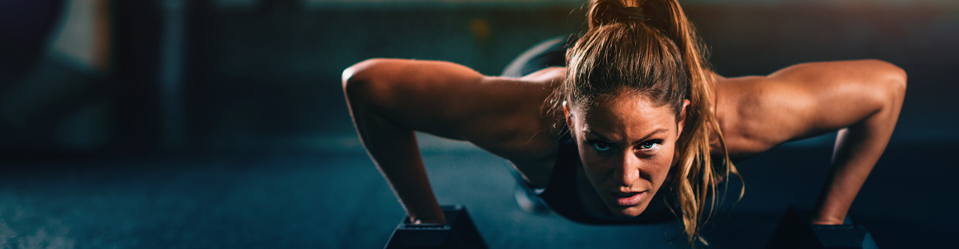 homem na academia levantando barra de peso